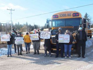 School bus operators and drivers met across the road from Clarendon Central Public School Tuesday morning waiting to escort LDSB Director of Education Krishna Burra to the North Addington Education Centre to draw attention to proposed changes in how busing contracts are awarded. Photo/Craig Bakay